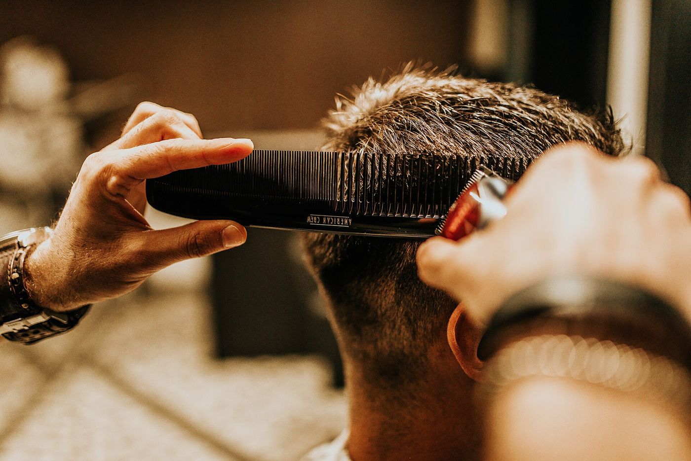 Corte com máquina e pente na barbearia